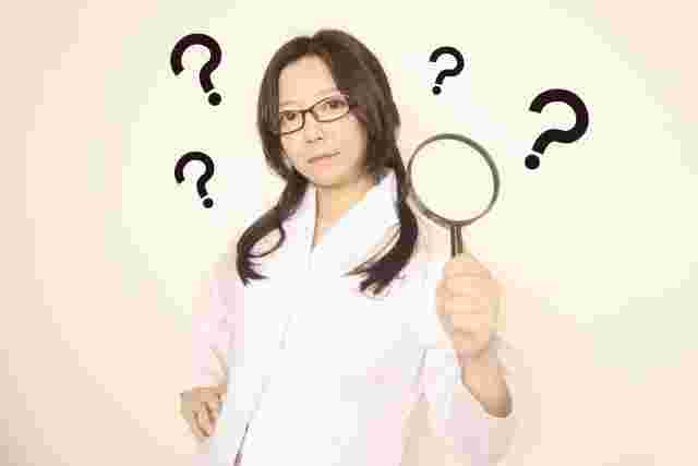 虫眼鏡を持ちクエスチョンマークの女性