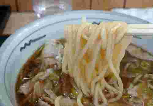 肉うどんを箸でつまんでいる様子