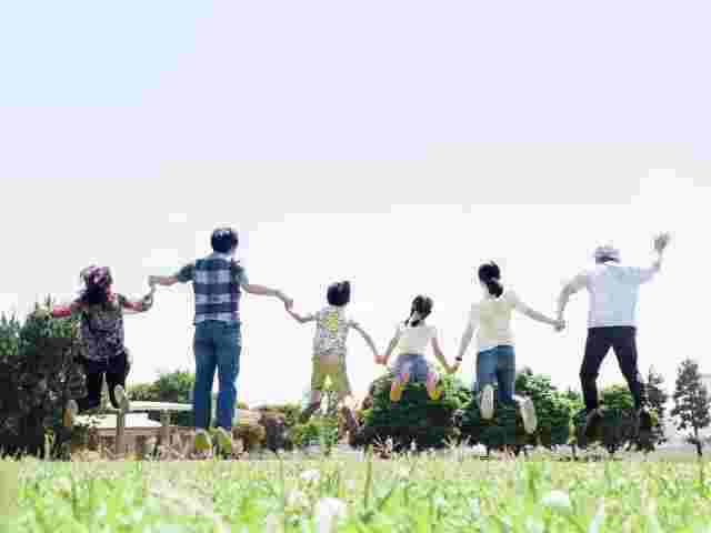 芝生でジャンプする家族