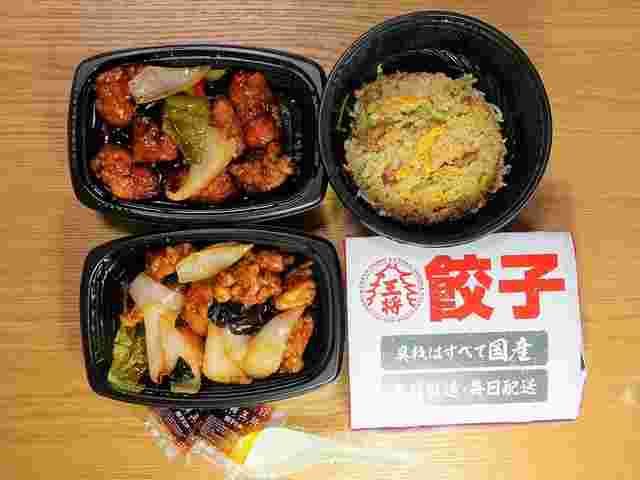 持ち帰りパックに入った酢豚や炒飯