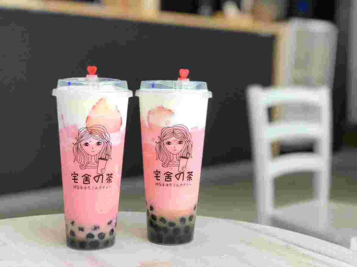 女性のロゴがおしゃれなカップに華やかなピンクのタピオカドリンクが入っている