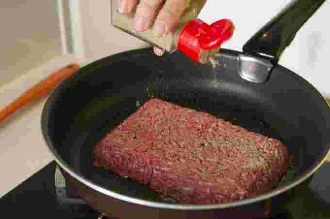合いびき肉にコショウをかけている