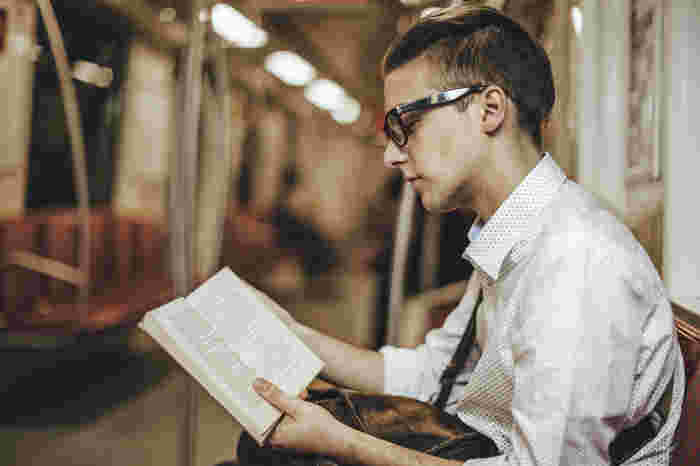メガネをかけて本を読む男性