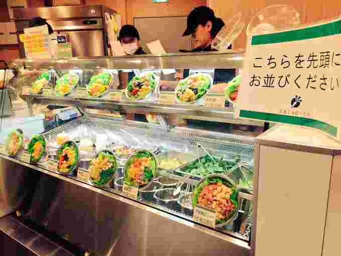 サラダイスの店頭に並ぶショーケースとスタッフ