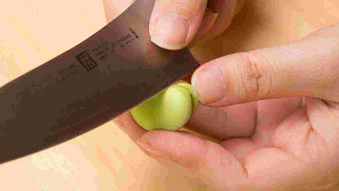 豆のくぼみに切り込みを入れている様子