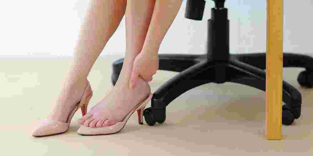 ヒールを脱いでむくみを気にする女性の足元