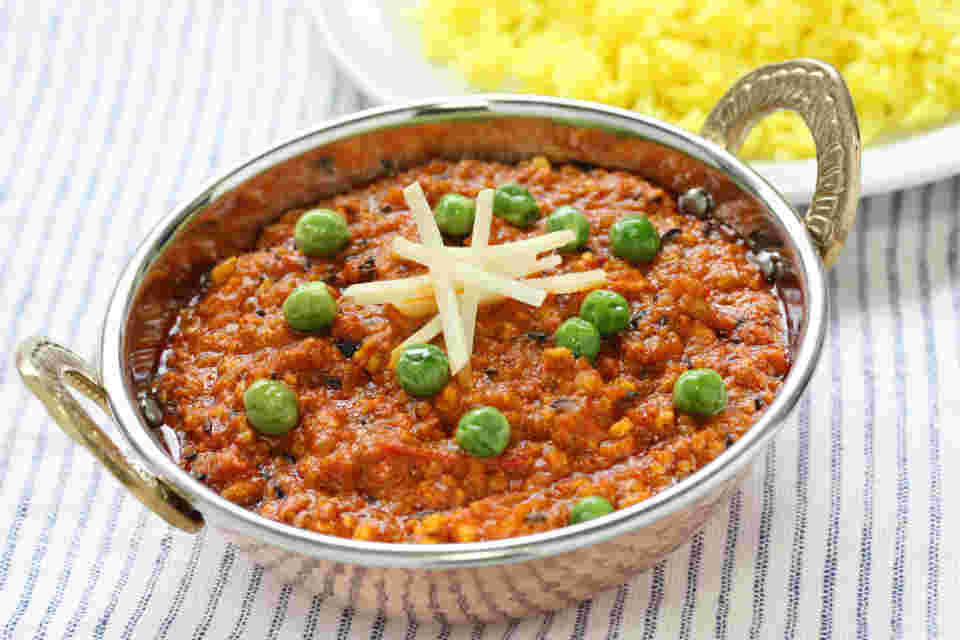 ストライプのテーブルクロスの上にボールと皿に食べ物が載せてある様子。