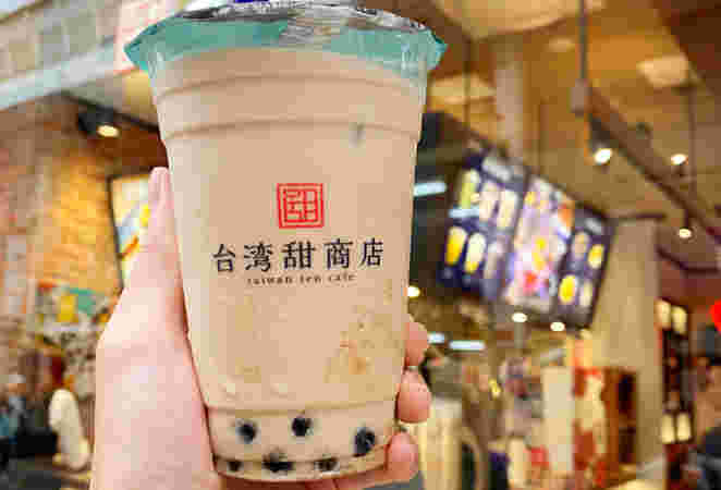 台湾甜商店の店舗を背景にしたタピオカミルクティー