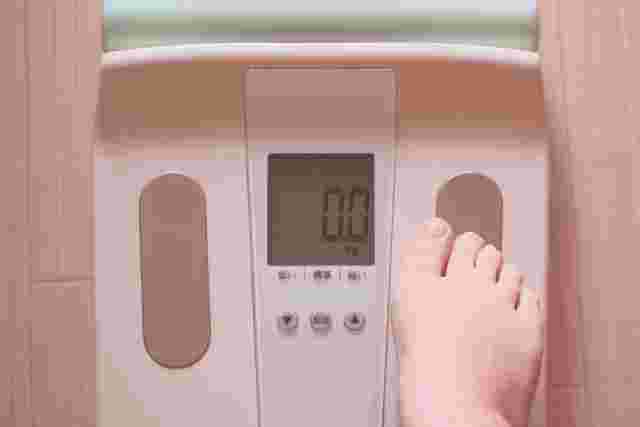 体重計に片足をのせている状態の画像。