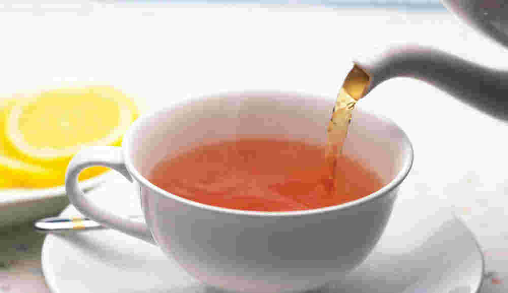 ポットから紅茶を注いでいる