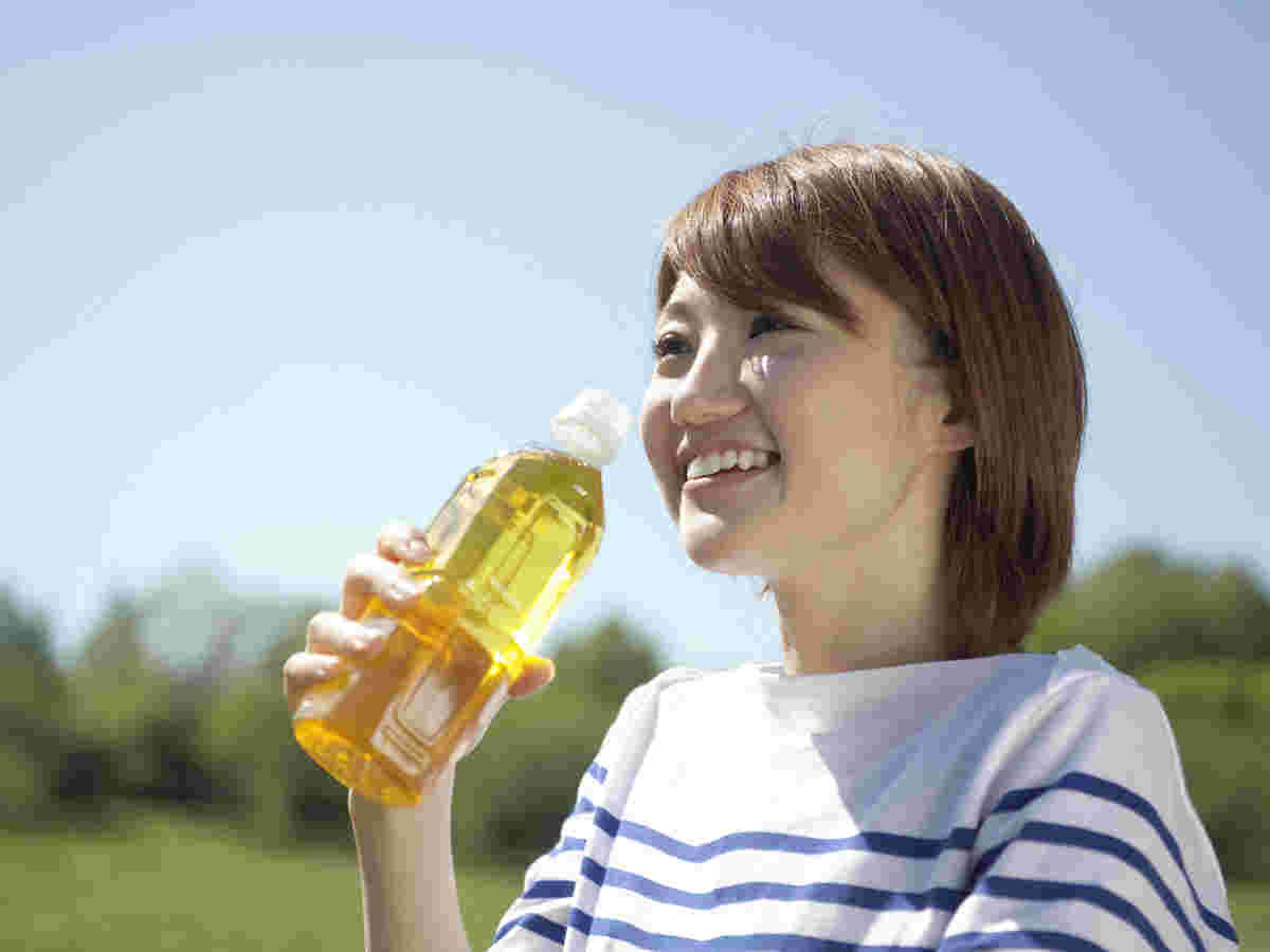 ペットボトルのお茶を飲む女性