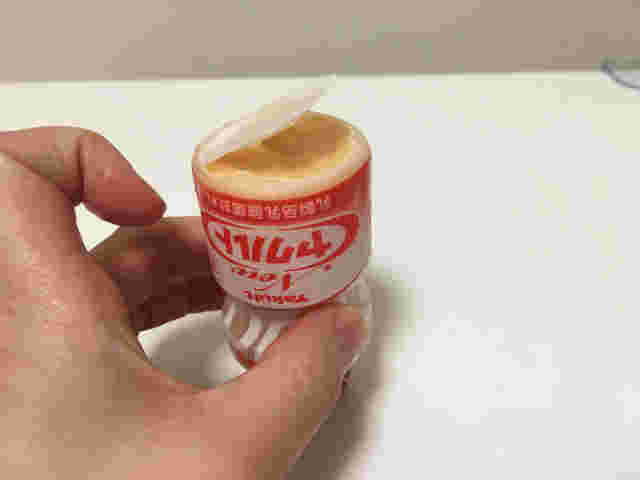 冷凍したヤクルトの底を開けている