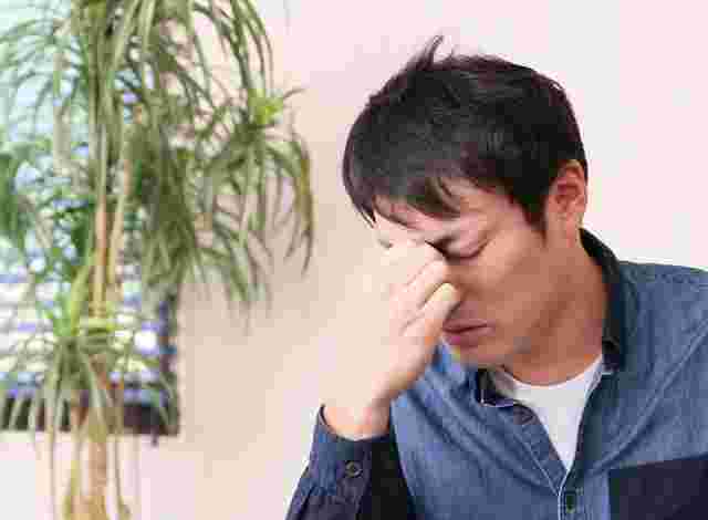 鼻をおさえる男性