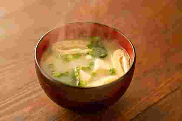 豆腐、油揚げ、ネギの入った味噌汁から湯気が出ている