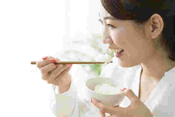 美味しそうにご飯を食べる女性