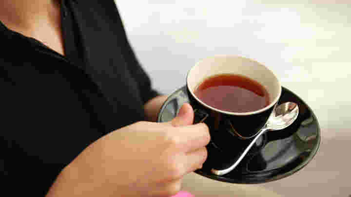 ソーサ―を持ち上げて紅茶を飲む