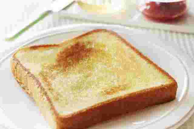 フライパンで焼いた焦げ目のついたトーストが白い皿にのせられている
