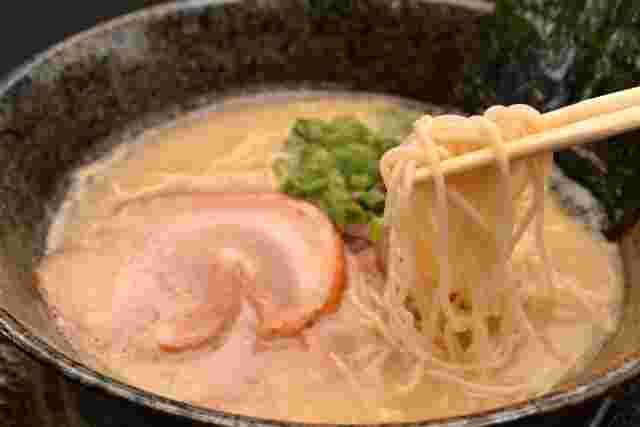 とんこつラーメンの麺を箸で持ち上げる様子