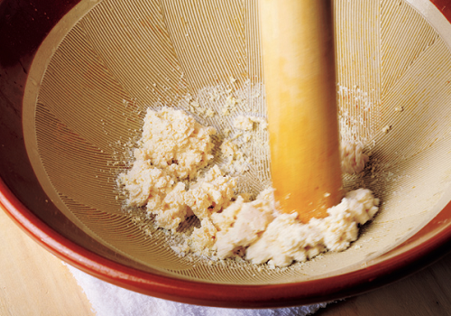 豆腐をすり鉢で潰している