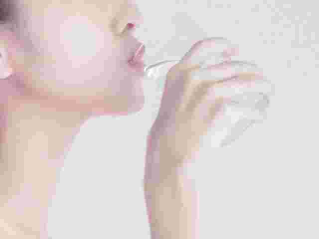 水を口に入れる女性