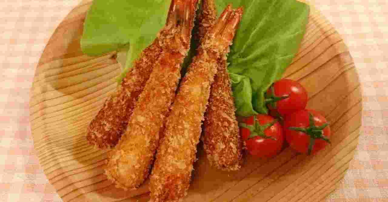 木のお皿に盛り付けられたエビフライとミニトマト
