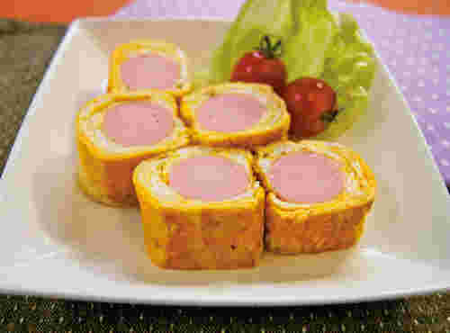 ホモソーセージを入れて巻いた卵焼きにプチトマトとレタスを添えている