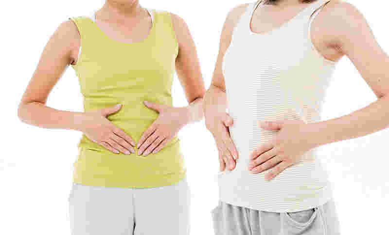 女性がお腹のあたりを押さえている