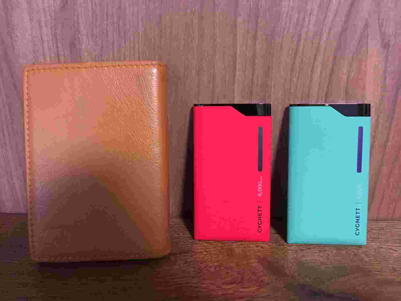 モバイルバッテリーを文庫本とサイズ比べてしている