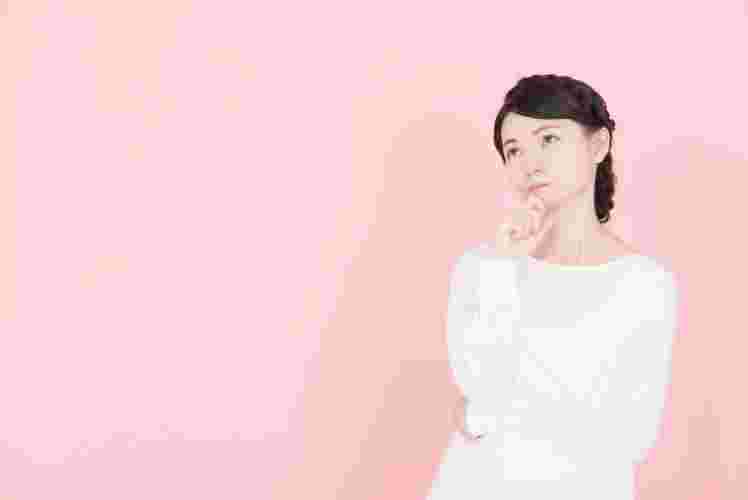 上を見上げて悩む女性