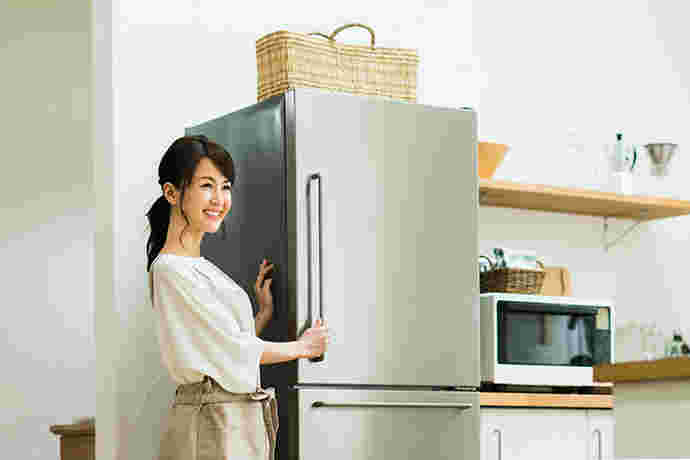冷蔵庫を閉める笑顔の女性