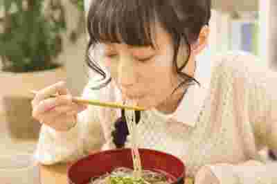 麺を食べる女性の画像