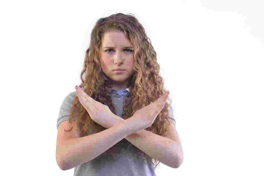 拒否のポーズをする女性の様子。