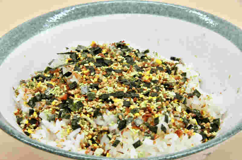 ごはん茶碗に盛りつけられたふりかけのかかったごはん
