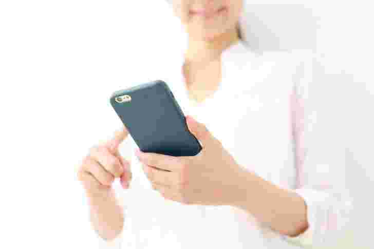 スマホを触る笑顔の女性
