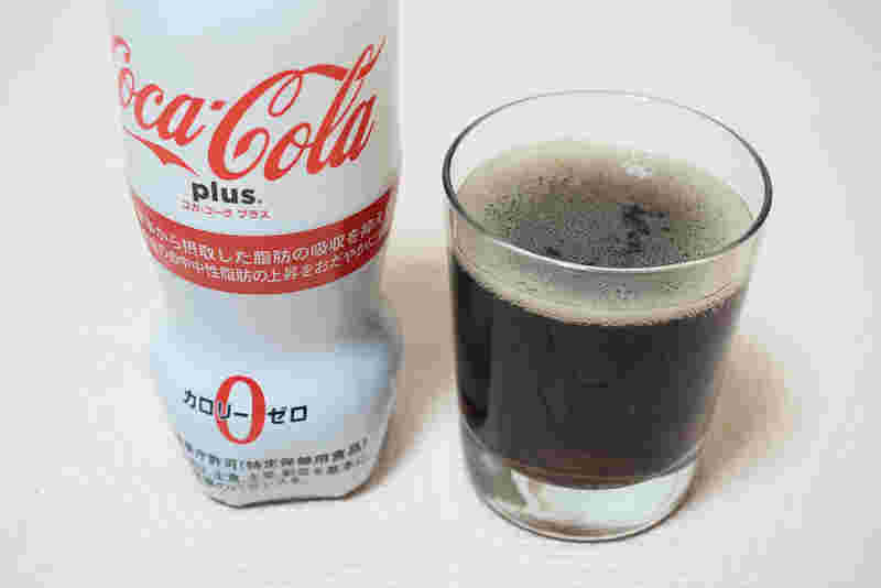飲料水が入っているペットボトルとグラスがテーブルに置いてある模様。