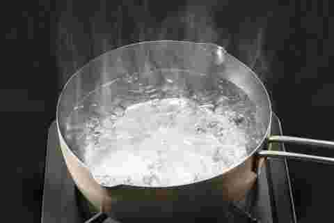 コンロの上に置かれた鍋の中でお湯が沸騰している様子