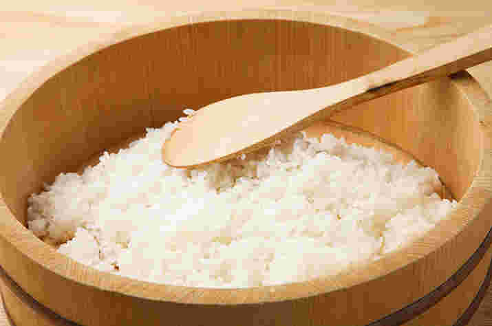 おひつの中の酢飯をしゃもじで混ぜている