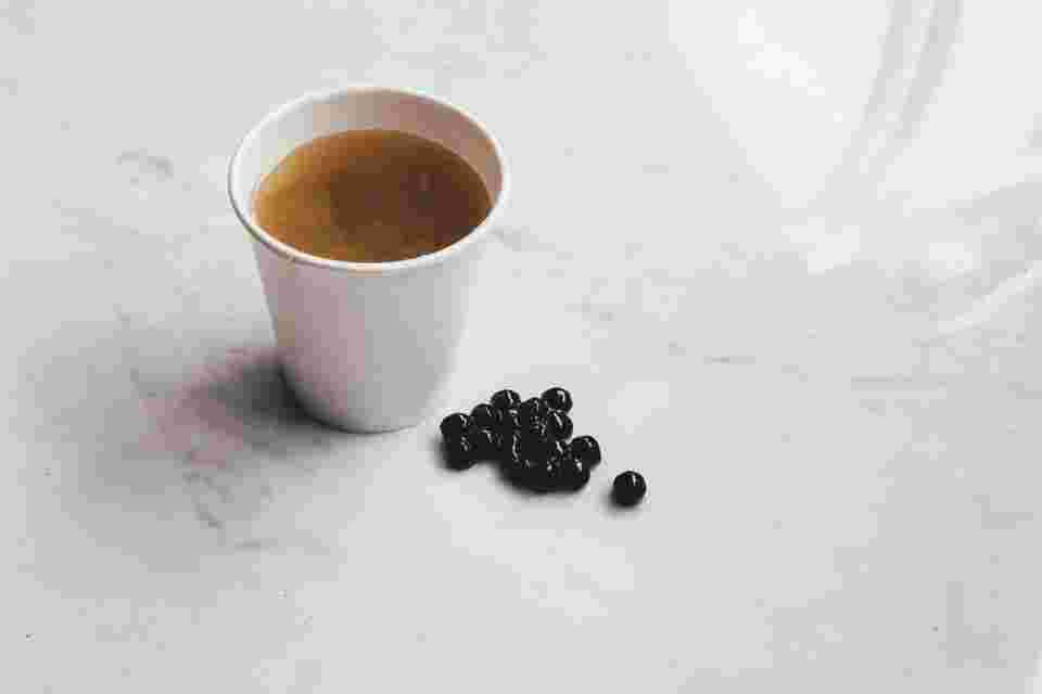 白いテーブルに並べられたコーヒーとタピオカ