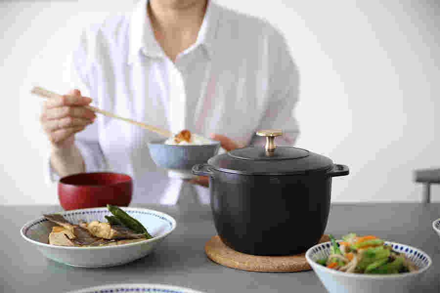 ストウブ鍋で作ったご飯とおかずを食べる人
