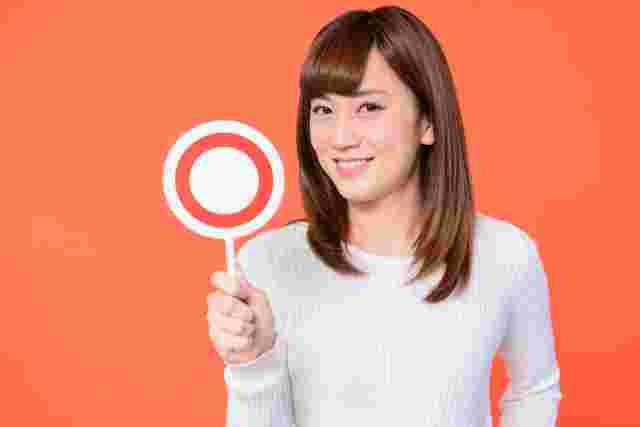 丸を持ち微笑む女性
