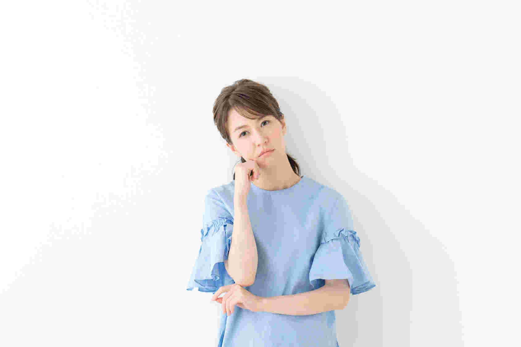 頬杖をついて悩む女性