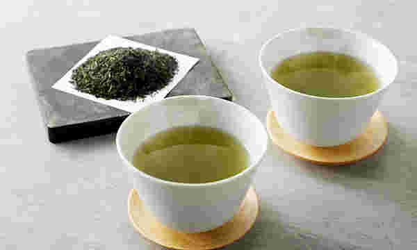 湯吞みに注いだ緑茶とお茶の葉