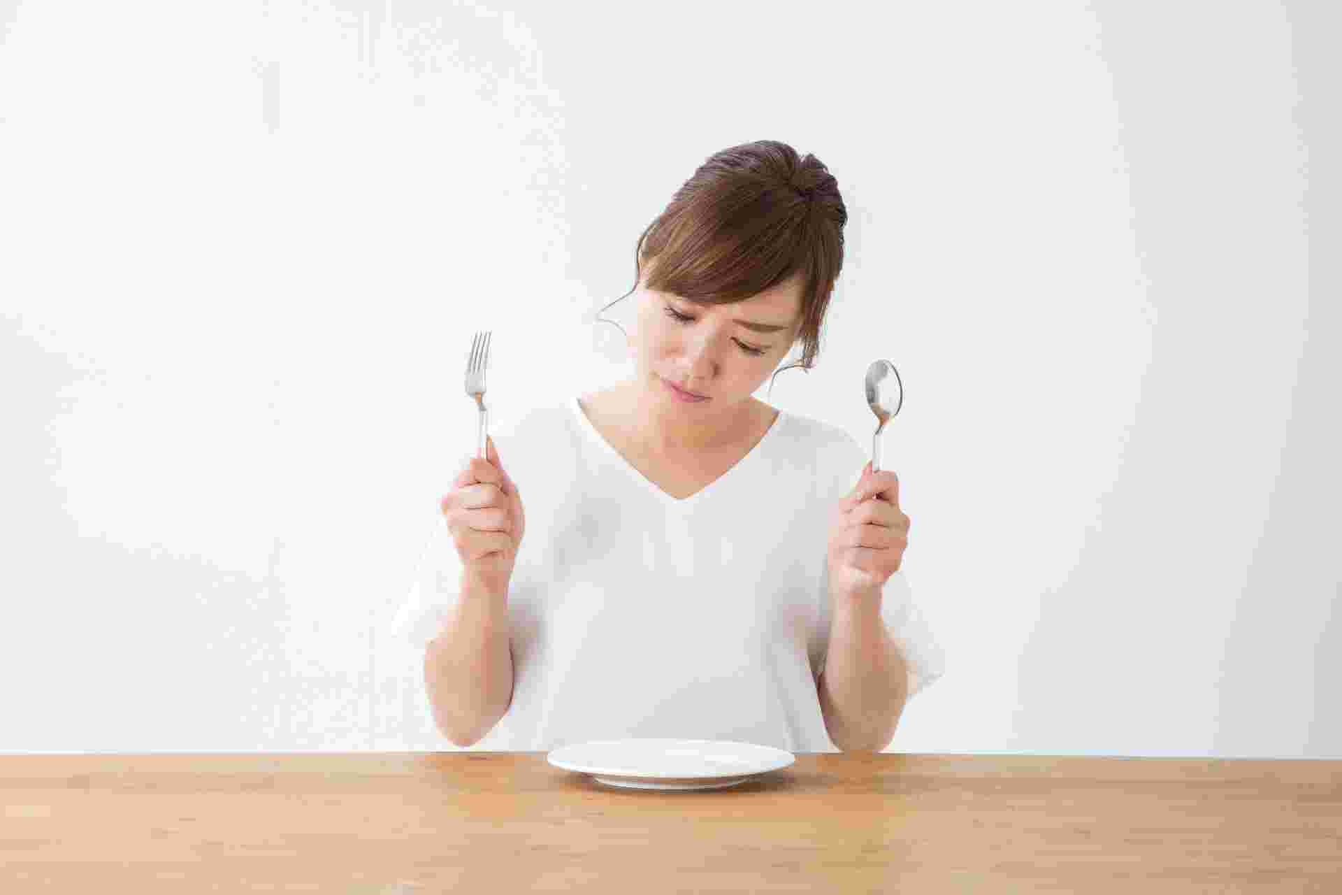 ナイフとフォークを持ってお皿を見る女性