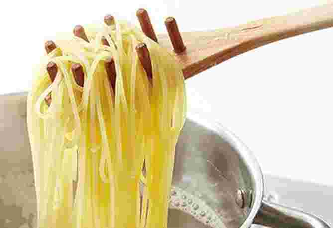 茹でたパスタを持ち上げている