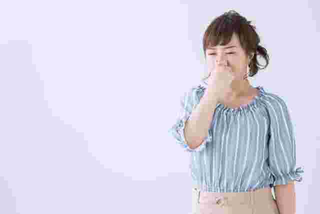鼻をつまむ女性