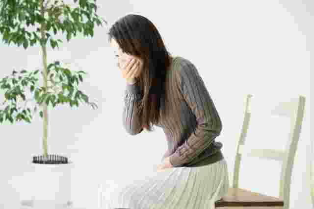 口をおさえる女性