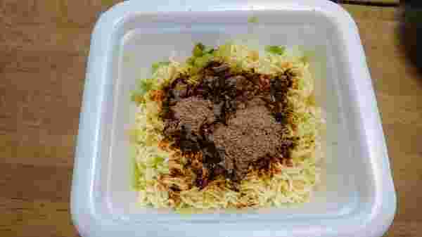 カップ焼きそばの湯切りした麺に粉末ソースを掛けて混ぜる前の様子