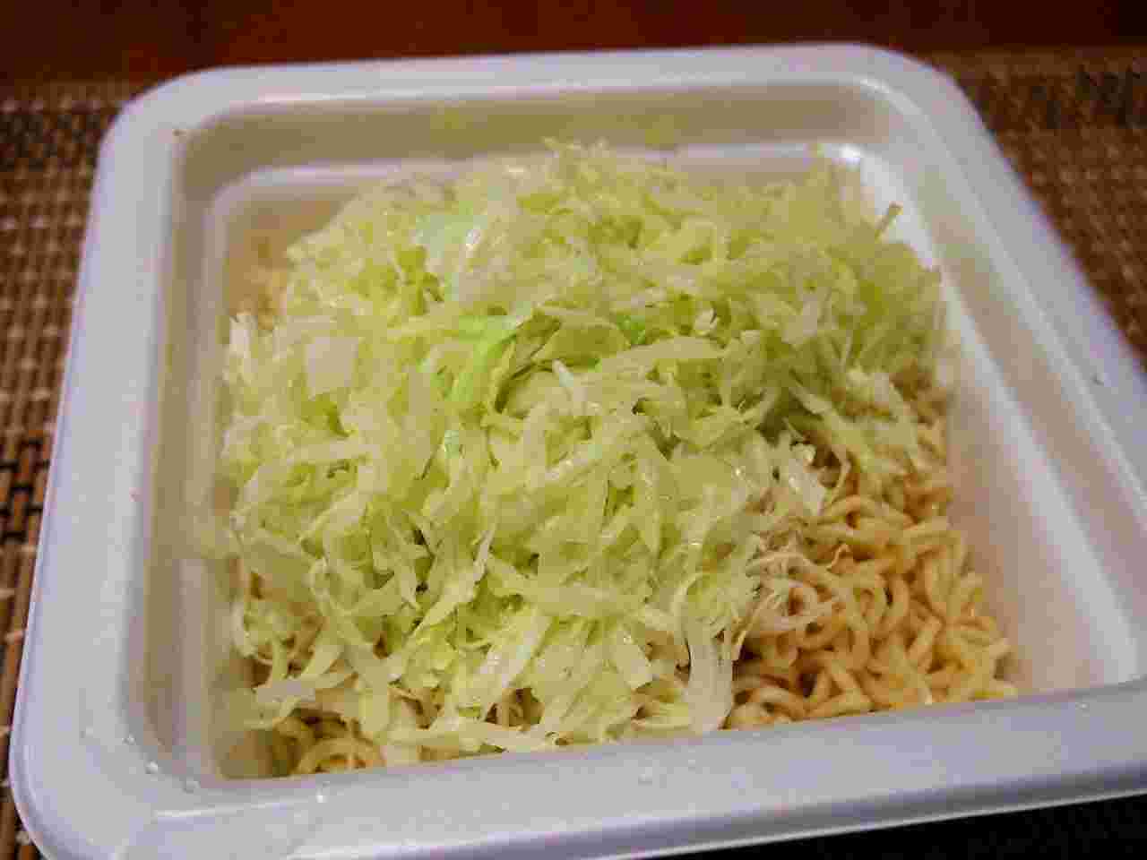 カップ焼きそばの出来上がりの上に千切りキャベツをトッピングした様子