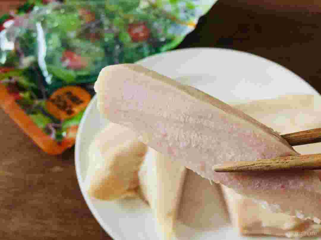 業務スーパーのサラダチキンを切って箸でつまんでいる