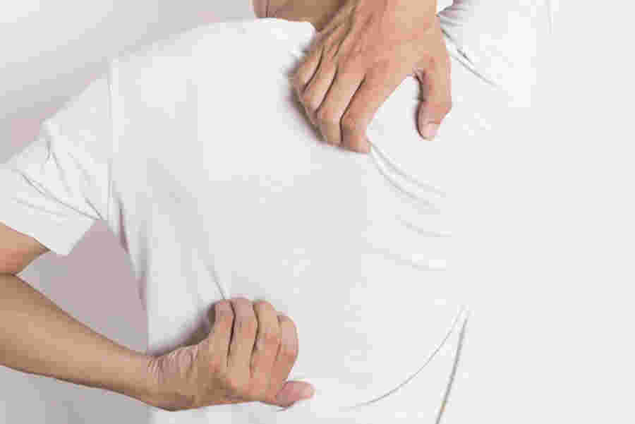 背中を搔く男性の画像
